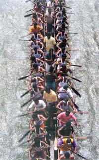 Oarsmen row their boat towards the staring line