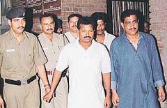 A team of the Orissa police led by Inspector Prabhat Kumar Pradhan (right) takes away Nru Singha Charna Malik