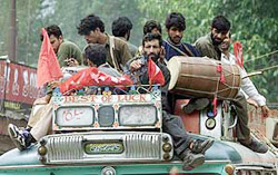 Supporters of National Conference's candidate Javed Shah play drums