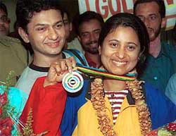 Anjali Vedpathak Bhagwat flanked by her proud husband Mandar shows her champion of champions medal 