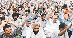 Members of the Punjab Small Industries and Export Corporation Staff Association stage a dharna in front of Udyog Bhavan in Sector 17