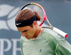 Roger Federer of Switzerland tosses his racquet during his match with Jiri Vanek of the Czech Republic