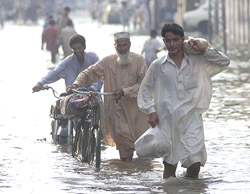 People wade through rain water after a heavy downpour in Lahore on Tuesday.