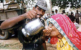 An Army jawan offers water