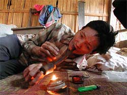 Karen elder Leesea lights up an opium pipe