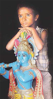Young Dula Ram waits for customers for his idol of Lord Krishna