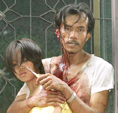 A Thai man known only as "Tee," high on metamphetamine drugs and covered in his own blood after cutting himself in a rage, takes 19-year-old university student Patcharapan Tiyawanich hostage