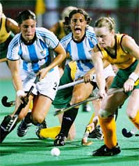 Argentina's Mercedes Margalot (C) shouts as teammate Claudia Burkart and Australia's Katrina Powell try to reach the ball
