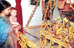 A mother and her child rock the �jhoola� during Janamashtami celebrations