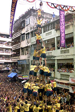 A human pyramid of youngsters reaches out to grab a clay pot