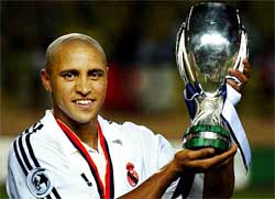 Real Madrid's Brazilian player Roberto Carlos holds the trophy after winning the UEFA Super Cup match