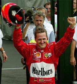 German Ferrai driver and world champion Michael Schumacher raises his arms in victory after he took pole position 