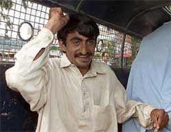 A supporter of former Pakistan Prime Minister Benazir Bhutto punches in the air from inside a police van in Karachi