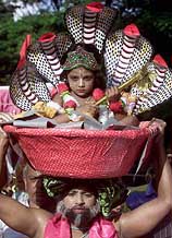 A devotee carries a small boy dressed as Hindu God Lord Krishna