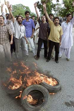 Supporters of former Pakistan Prime Minister Benazir Bhutto burn tyres