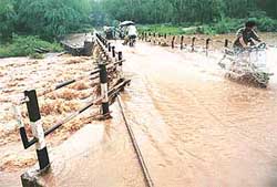 Water flows over the Makhan Majra bridge after heavy rain lashed Chandigarh on Sunday morning