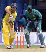 Australia's batsman Michael Bevan hits the ball away watched by Kenyan wicketkeeper David Obuya