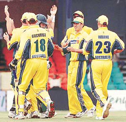 Pakistan batsmen Saeed Anwar walks through Australian team members celebrating his dismissal