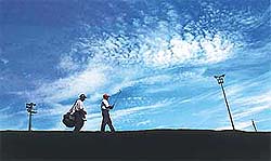 A golfer spans the vastness of the golf course that looks like a spotless bedspread under a spotted deep blue sky in Chandigarh