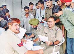 Police personnel verify documents of servants and tenants during a verification drive in Sector 18, Chandigarh, on Sunday