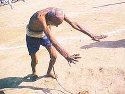 Maghar Singh bends a steel rod at the Kot Gangu Rai rural sports meet