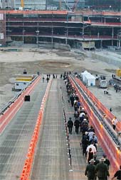 Firefighters and construction workers file into the pit