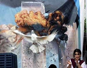 A Pakistani supporter of the World Minorities Alliance, standing in front of a mural depicting last year's attack on New York, releases a dove as a symbolic with for universal peace, in Islamabad on Wednesday