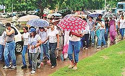 Students of city colleges march through the city on Thursday carrying umbrellas to protest against Panjab University decisions
