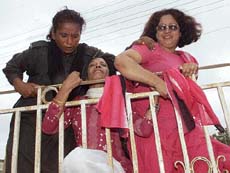 A policewoman (L) tries to stop supporters of Benazir Bhutto