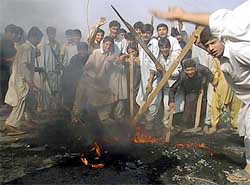 Pakistani protesters burn tyres during a demonstration in Pishtakhara, a suburb of Peshawar
