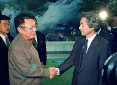 North Korean leader Kim Jong II (left) smiles as he shakes hand