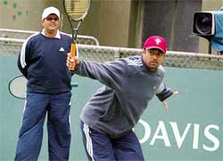 Davis Cup tennis players Leander Paes is watched by his team captain Ramesh Krishnan during practise in Adelaide,