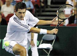 Britain's Tim Henman plays a shot against Thailand's Danai Udomchoke