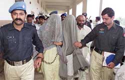Pakistani policemen escort bombing suspects Mohammad ismail and Maqsood Ahmed after producing them before a judicial court
