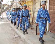 Riot police patrol a street in Vadodara city, about 70 km from Ahmedabad, on Saturday