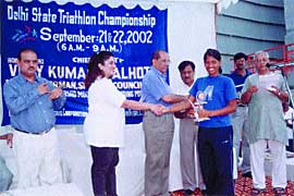 AICS chairman V. K. Malhotra presenting the trophies to triathlon winners 