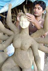 An idol maker from West Bengal works on a representation of the Hindu Goddess Durga