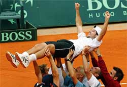 France's Davis Cup team carries Sebastien Grosjean after he defeated Andy Roddick of the USA in their reverse singles match