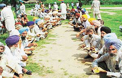 Farmers sit on an indefinite dharna which started on Monday, prepare for a community lunch near the Matka Chowk.