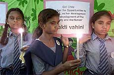Indian girls hold candles during a vigil