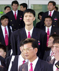 2.35 metre (7.7ft) Ri Myung-hun (R), the tallest player on the North Korean basketball team, arrives at Kimhae airport near Busan, South Korea, on Monday. 