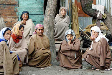 Kashmiri women sit in front of a polling station