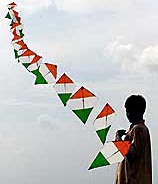 A boy flies a string of kites