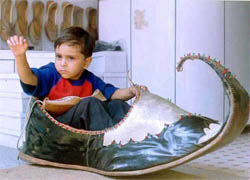 A kid sits in the world's biggest Punjabi jutti