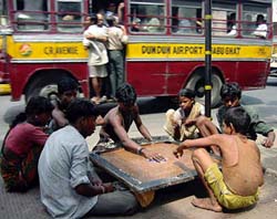 People living on the pavement play carom