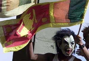 A Sri Lankan supporter wearing a mask waves the national flag 