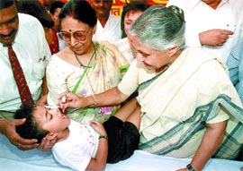 Delhi Chief Minister, Mrs Sheila Dikshit, administers polio drops to a child on the occasion of pulse polio campaign