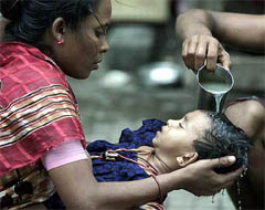 Asha holds her four-year-old sick daughter Durga