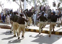 The Pakistani police run to disperse a crowd 