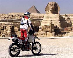 One of 82 motorcycling contestants speeds past the 4,500-year-old Sphinx and pyramids at the start of the Rally of Egypt 2002 race